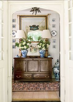 an entry way with blue and white vases on the dresser