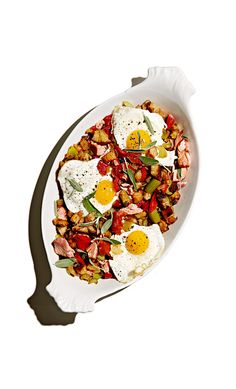 a white plate topped with fried eggs and vegetables