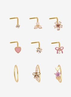 Gold-tone set including 6 nose studs and 3 nose hoops with pink heart  bow  star and flower designs. Plus  opalescent  faux pearl and pink gem detailing.Jewelry care: Wash with antibacterial soap and warm water.Piercing care: Wash hands thoroughly  then clean piercing with H2Ocean (sold separately) or saline solution.316L surgical steel Nickel-free2mm - 7.5mm designsSet of 9Use in healed piercings only. Remove immediately if irritation occurs. Do not use harsh or alcohol-based che Bow Nose Piercing, Cute Nose Jewelry, Cute Nose Piercing Jewelry, Faith Piercing, Cute Piercings Nose, Pink Piercings, Cute Nose Studs, Heart Nose Stud, Gold Nose Piercing