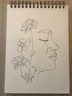 a drawing of a woman's face next to flowers