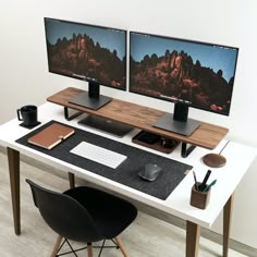 two computer monitors sitting on top of a white desk