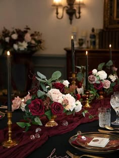 the table is set with flowers and candles