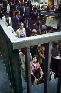 a group of people standing on the side of a train platform next to each other