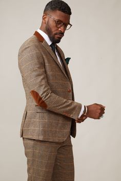 Inspired by old age country wear, the DX7 suit remains an ever so popular style, reminiscent of the 18th century. It is ideal for Autumn/Winter with its earthy colour palette and heavy fabric. A touch of modernism is added with a velvet contrast collar, elbow pads and pocket trims, nudging it back into the 21st century. Perfect for a rustic countryside wedding. Mix-and-match the waistcoat to differentiate from the groomsmen and match your accessories with the bridesmaid dresses. Looking for a pl Tailored Beige Tweed Jacket With Suit Collar, Brown Wool Suit With Herringbone Pattern, Winter Tweed Three-piece Suit For Work, Tailored Brown Tweed Jacket With Welt Pockets, Brown Tweed Jacket With Notch Lapel And Welt Pockets, Fitted Brown Tweed Jacket For Business, Beige Single Breasted Tweed Jacket For Tailoring, Beige Single-breasted Tweed Jacket For Tailoring, Beige Single Breasted Tweed Jacket