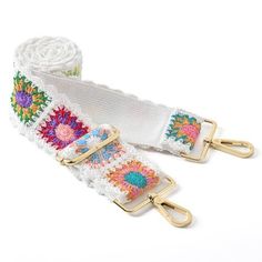 two white crocheted belts with gold metal buckles and colorful flowers on them