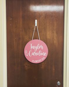 a wooden door with a sign that says taylor & careline on it and flowers hanging from the handle