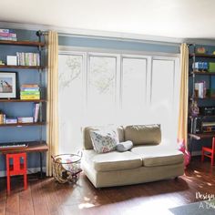 a living room filled with furniture and bookshelves in front of a large window