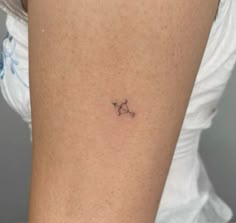 a small star tattoo on the back of a woman's arm