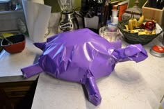 a purple cow statue sitting on top of a counter