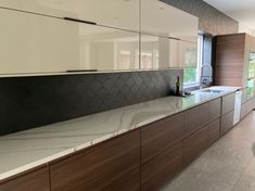 a kitchen with marble counter tops and wooden cabinets in the back drop off area is shown