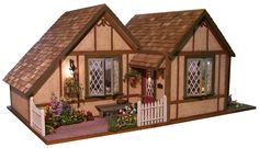 a doll house with flowers in the front yard