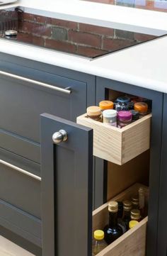 an open cabinet in the middle of a kitchen with spices and condiments inside