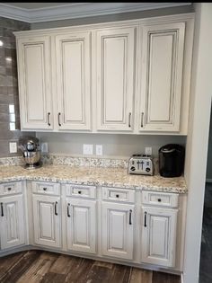 a kitchen with white cabinets and granite counter tops