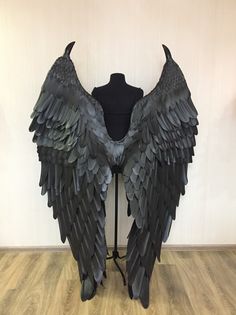 a mannequin with large black wings on it