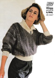 a woman wearing a sweater and leather pants in front of a white wall with her hand on her head