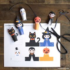 paper cut outs with halloween characters and scissors on top of a piece of white paper