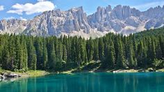 the mountains are reflected in the blue water