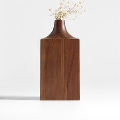 a wooden vase with white flowers in it