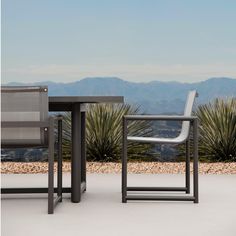 two chairs and a table with mountains in the background