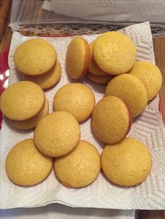 a bunch of yellow muffins sitting on top of a white paper towel next to a red bowl