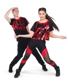 two people in red and black outfits posing for the camera with their hands behind their backs