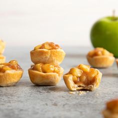 several mini apple pies on a table next to an apple