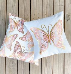 two pillows with pink and gold butterflies on them