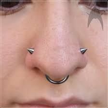 a woman's nose has two piercings on it