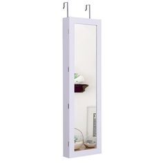 a bathroom mirror sitting on top of a white wall next to a shelf filled with items