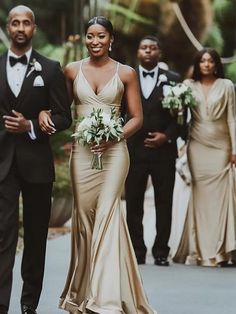 the bride and groom are walking down the street with their bridal party in the background