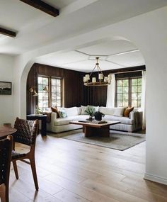 a living room filled with furniture next to a kitchen and dining room table on top of a hard wood floor