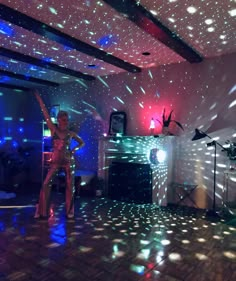 a woman standing on top of a wooden floor in front of a disco light wall