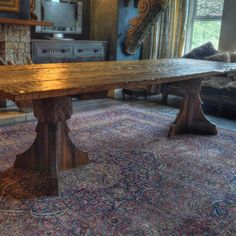 an old wooden table in the middle of a room with a rug on the floor