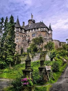 an old castle sitting on top of a lush green hillside