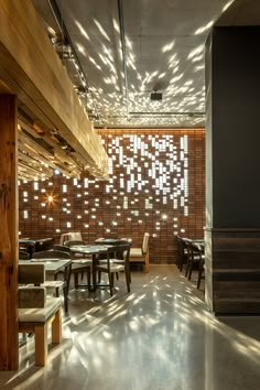 an empty restaurant with tables and chairs in front of a brick wall that has lights on it