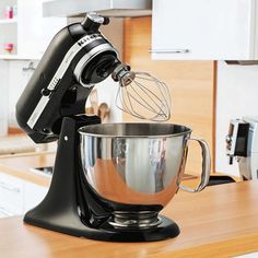 a black mixer sitting on top of a wooden counter