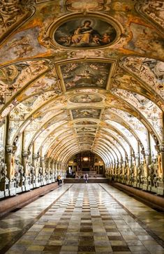 an ornate hallway with many paintings on the ceiling