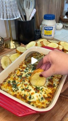 a person dipping something into a casserole dish