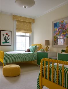 a bedroom with two twin beds and a yellow ottoman in front of the window,