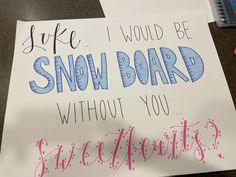 a handwritten snow board sign sitting on top of a desk next to a pencil