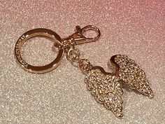 a gold keychain with an angel design on it's front and back ends