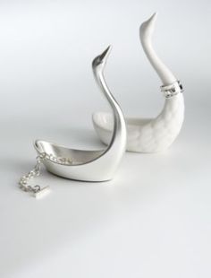 a white swan figurine sitting on top of a table next to a chain