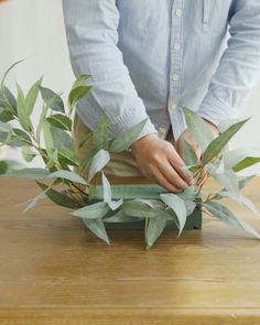 a person cutting up leaves on top of a wooden table