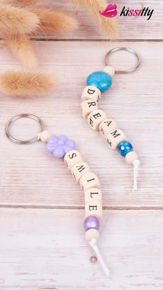 two key chains with words on them sitting next to a stuffed animal and a teddy bear