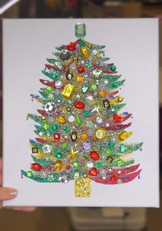 a hand holding up a card with a christmas tree made out of buttons and sequins