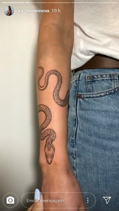 a woman's arm with a snake tattoo on the left side of her arm