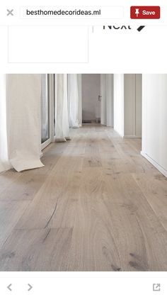 an image of a wood floor in the middle of a room with white walls and curtains