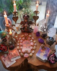 a wooden table topped with lots of different types of candles and other things on top of it