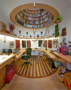 an office with bookshelves, desks and chairs in the middle of it