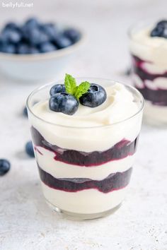 blueberry cheesecake trifle with whipped cream and fresh berries in the background, ready to be eaten